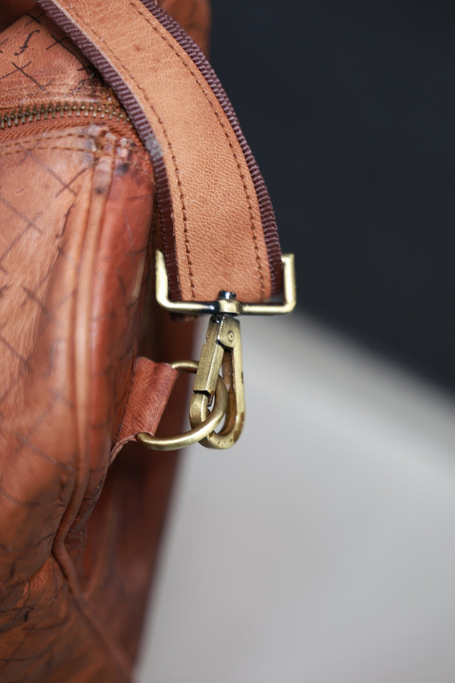 Side view of the brass shoulder-strap clip on the Orion leather duffel
