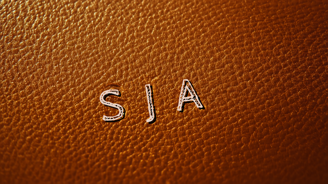 Personalised leather gifts — macro close-up of engraved monogram initials debossed into Frounder caramel full-grain leather beside a solid brass D-ring