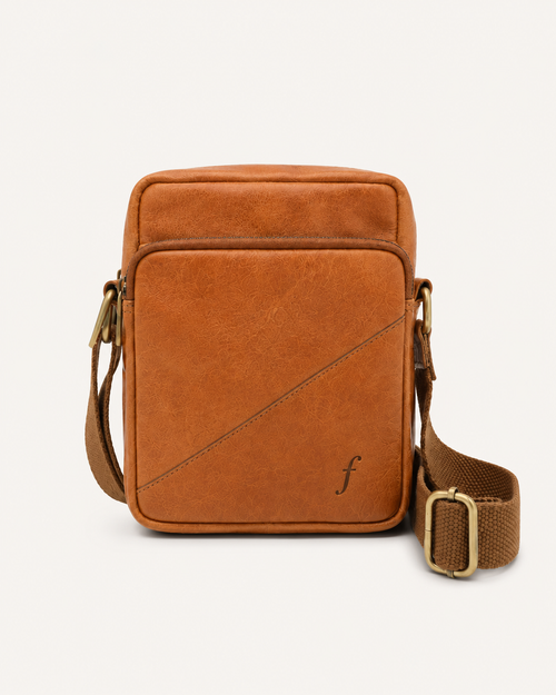Cosmo mini crossbody bag in full-grain leather with a solid brass clasp and adjustable strap