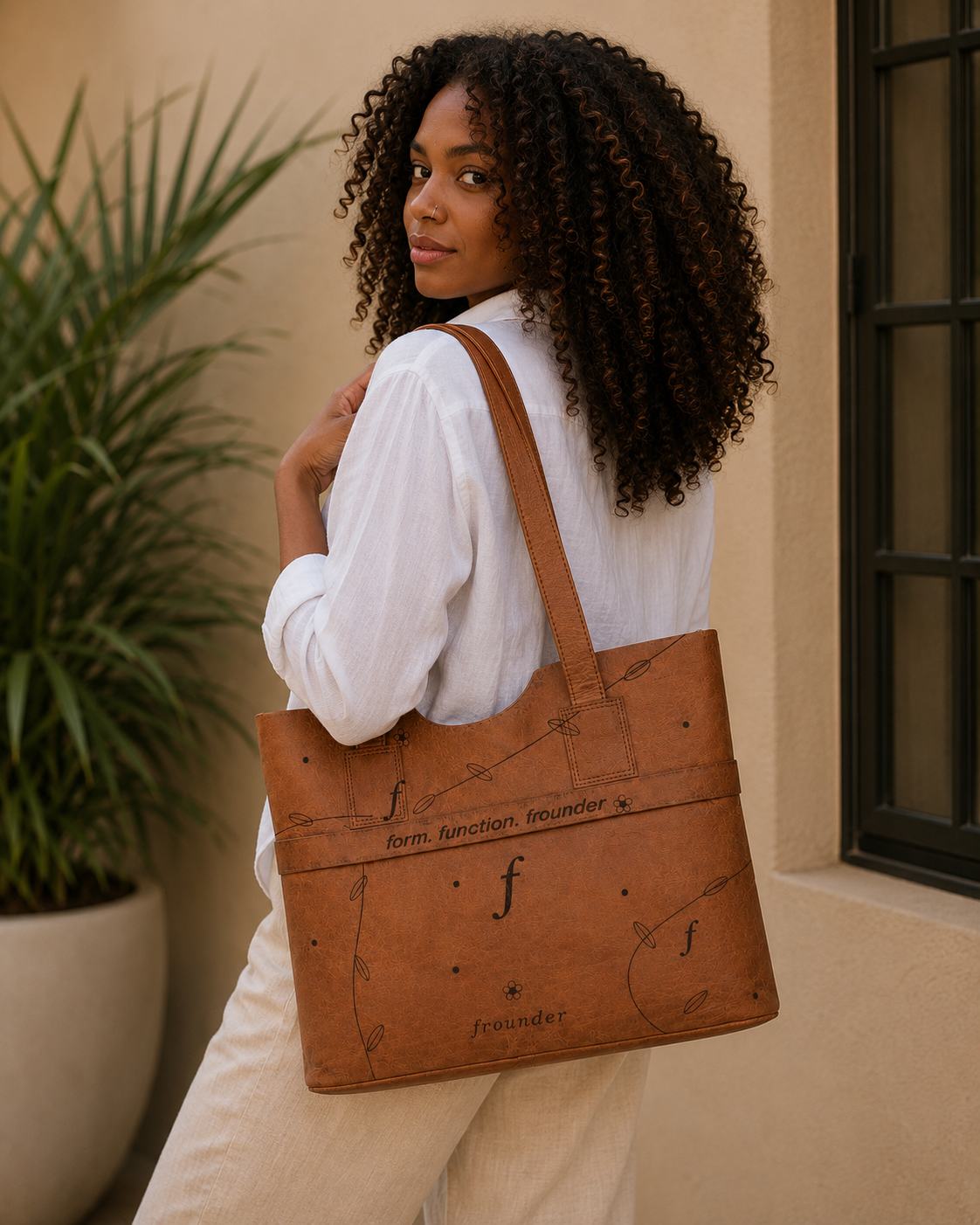 Woman carrying a tan Frounder Aurora leather work tote bag