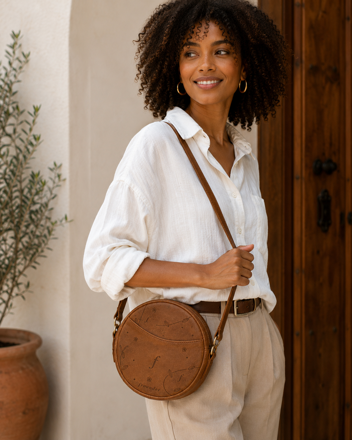Woman carrying a Frounder Orbit round leather crossbody bag
