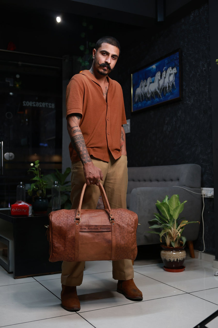 Frounder Orion leather duffel held at the side, showing the engraved weave pattern and form. function. frounder strap