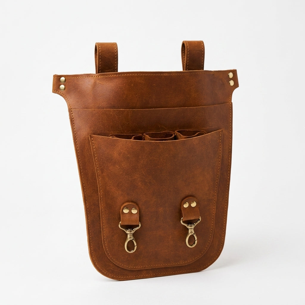 A brown leather organizer pouch with two top hanging loops, a large front pocket, and two brass snap hooks, shown on a clean white background.