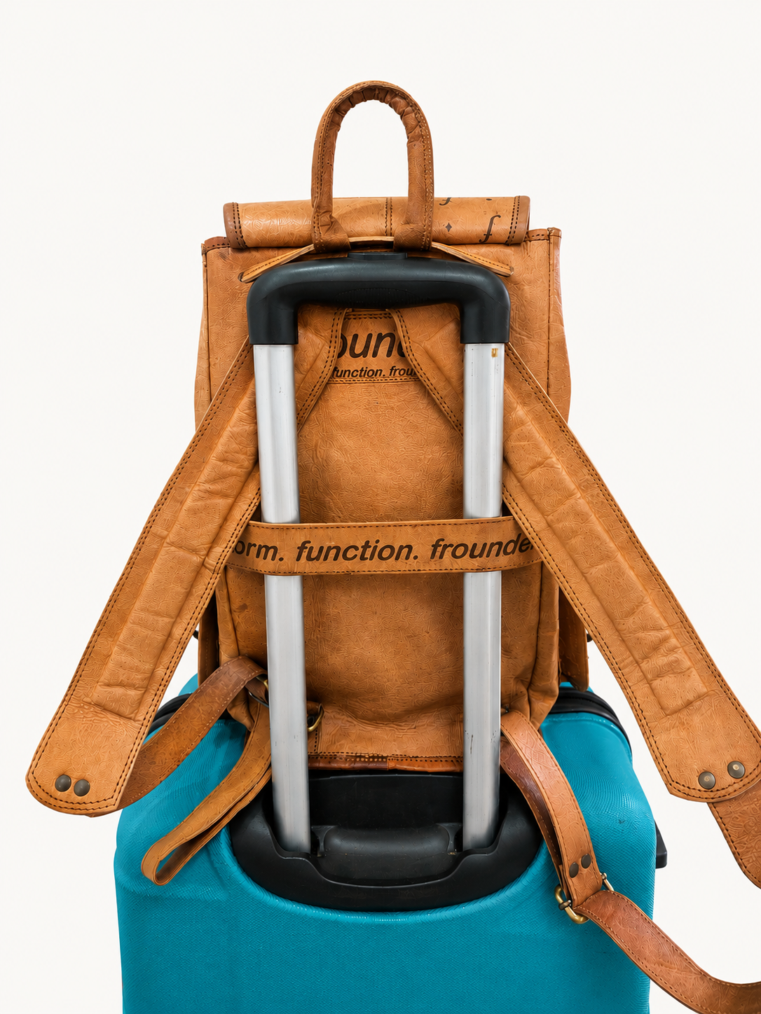 Brown leather backpack with a blue suitcase underneath on a white background